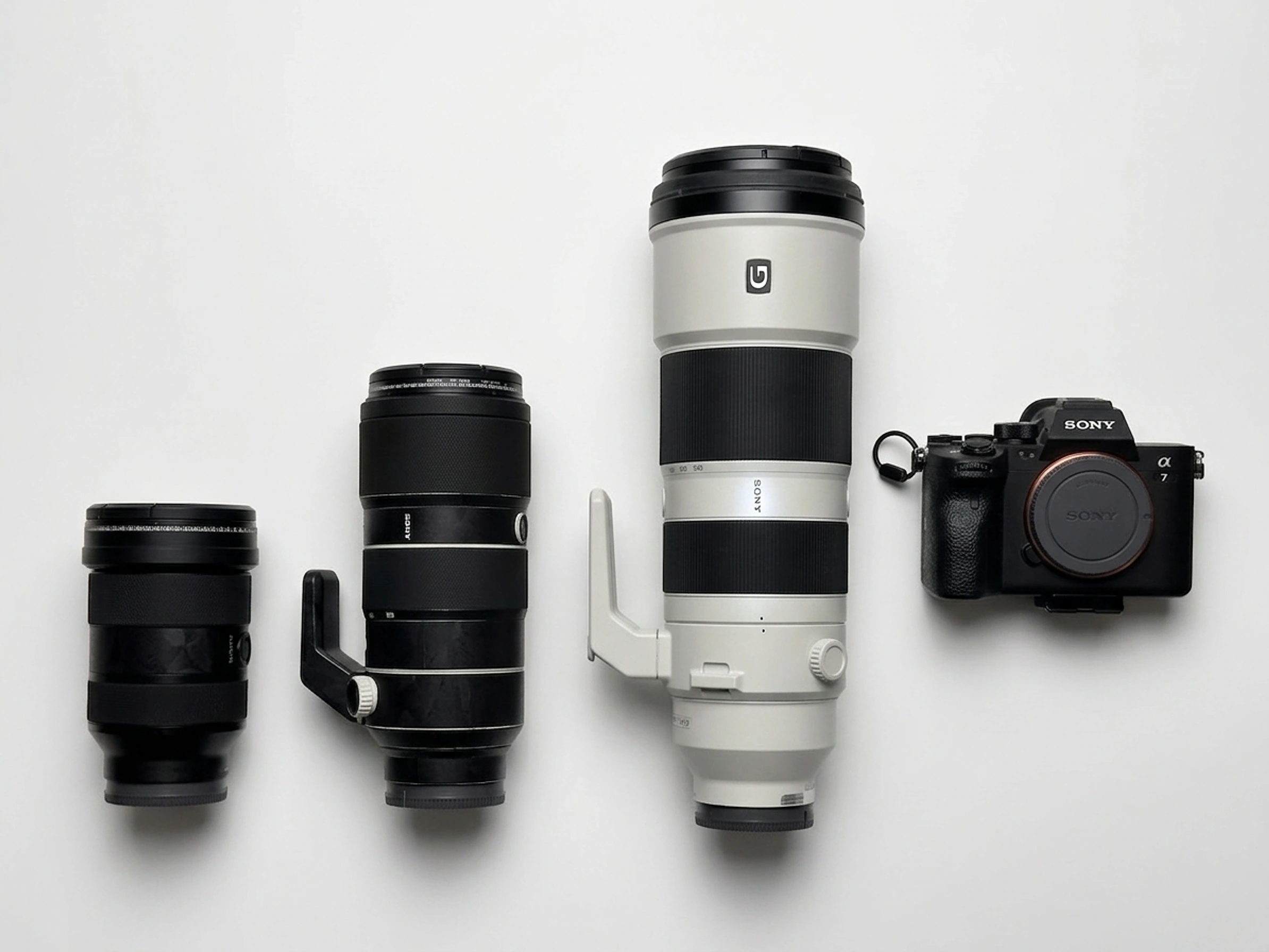 Kieran Lim’s camera body and three lenses arranged on a white surface