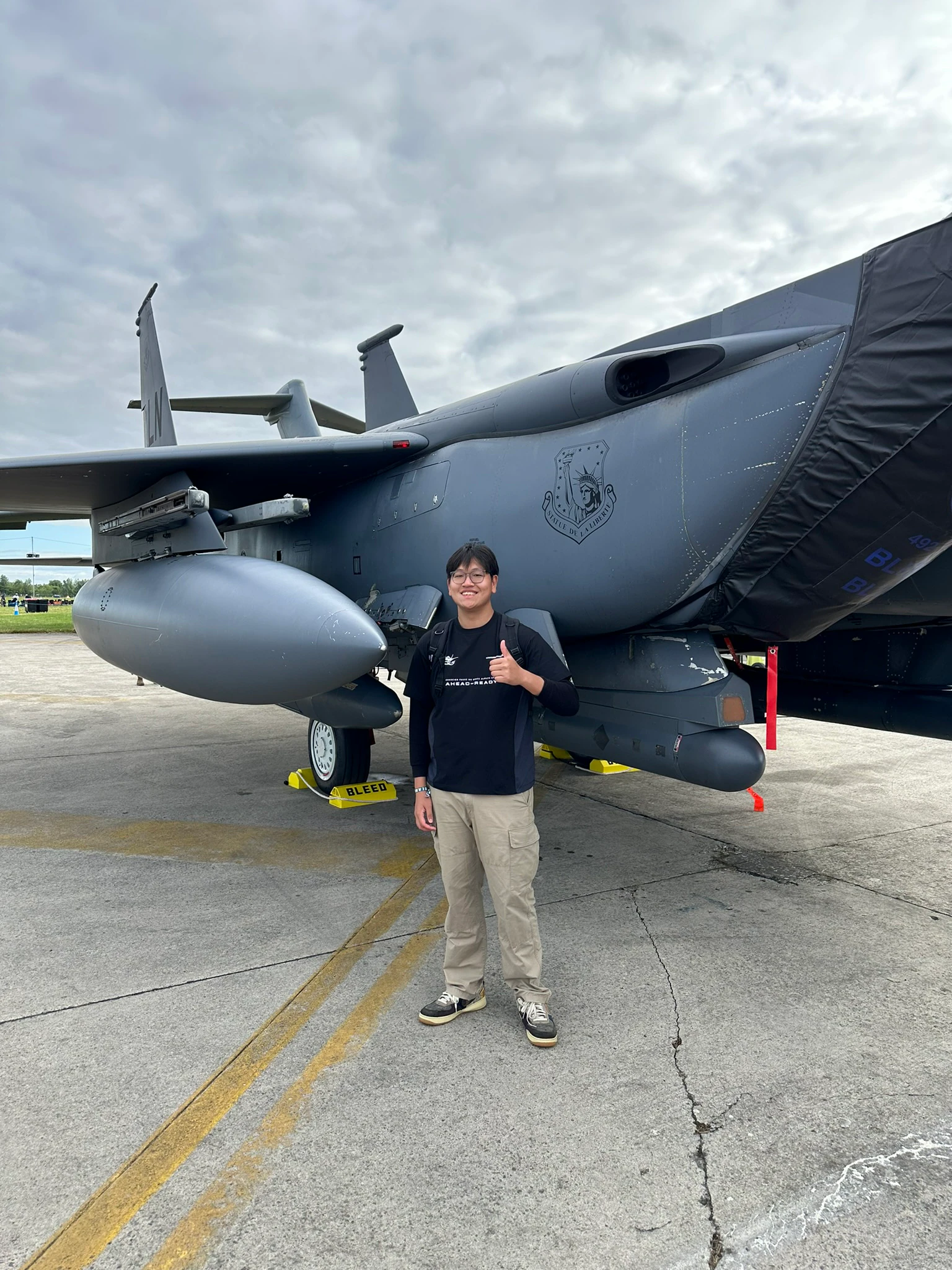 Kieran Lim standing beside a military aircraft