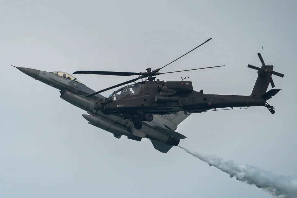 Two military helicopters crossing in flight
